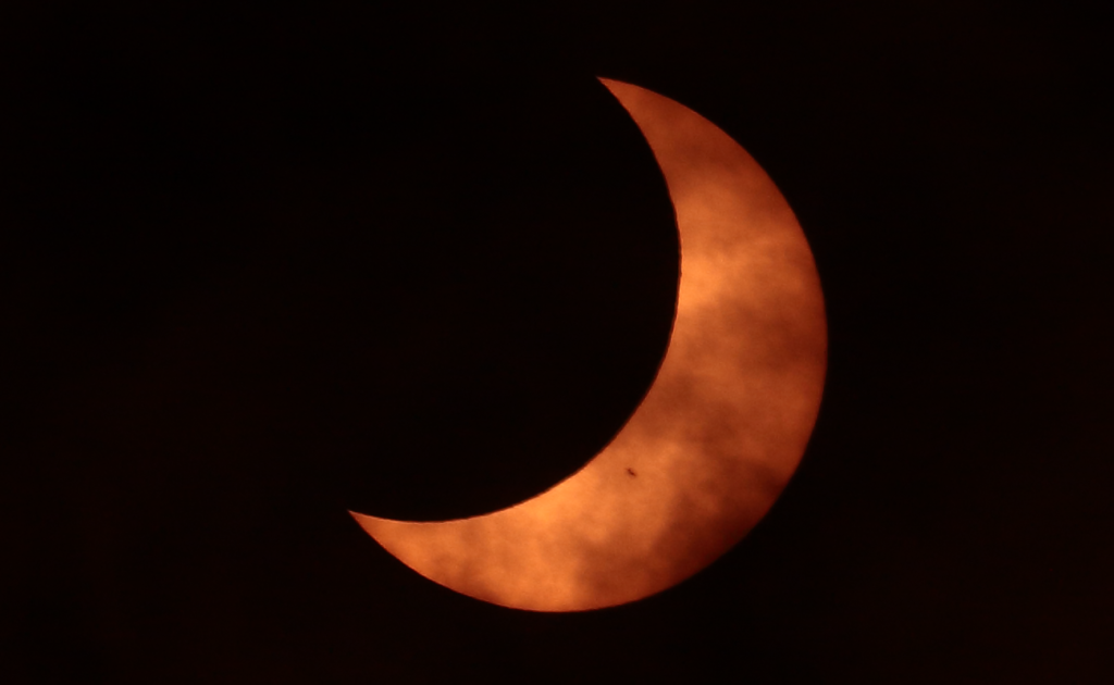 Partial eclipse of the Sun. A sunspot is visible.